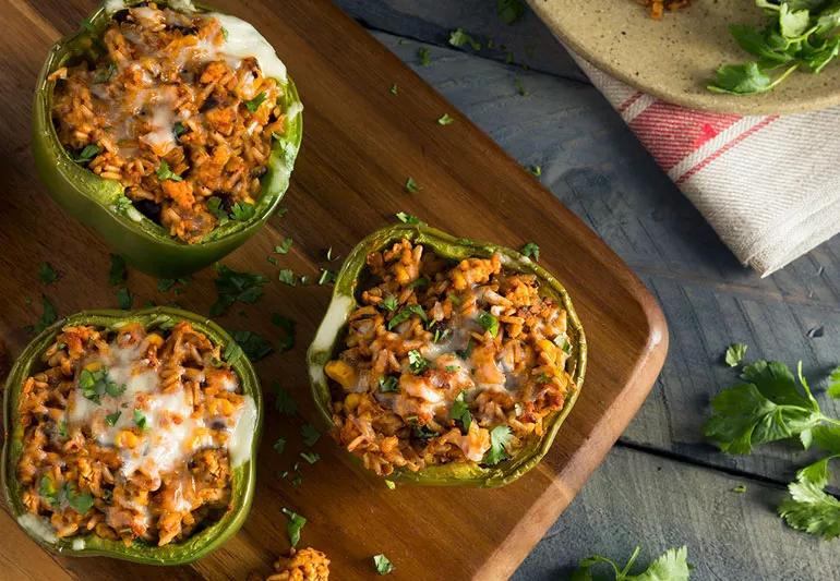 Closeup from top of turkey stuffed peppers on a wooden serving tray.