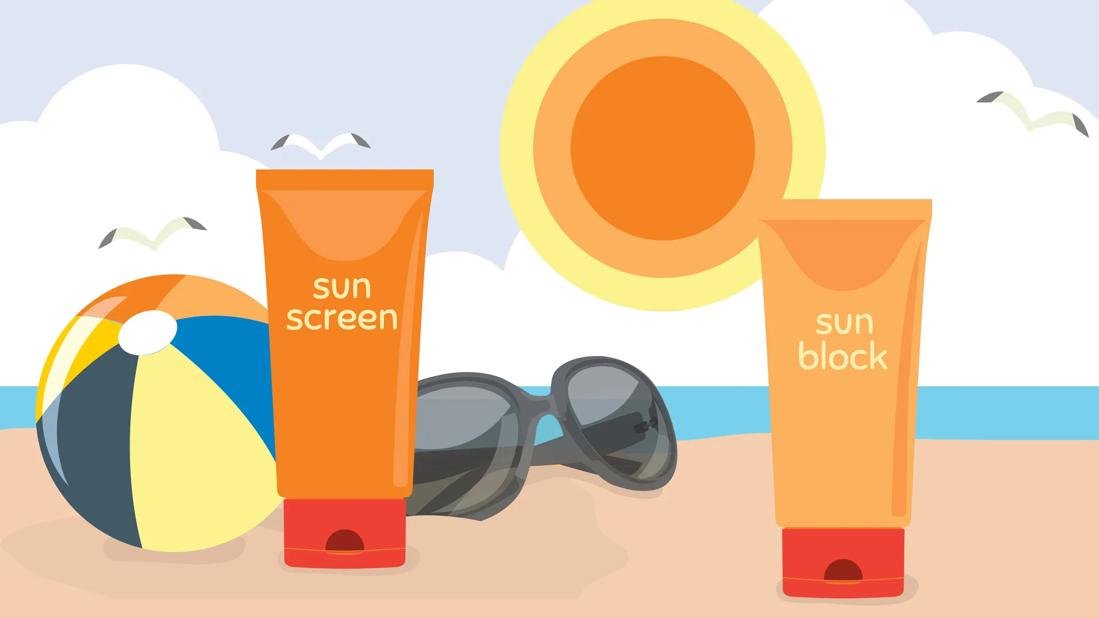 Tube of sunblock and tube of sunscreen in the sand on a beach