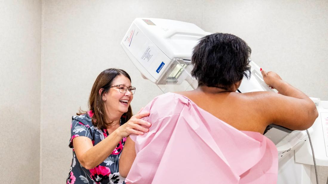 Smiling healthcare provider helping female get a mammogram