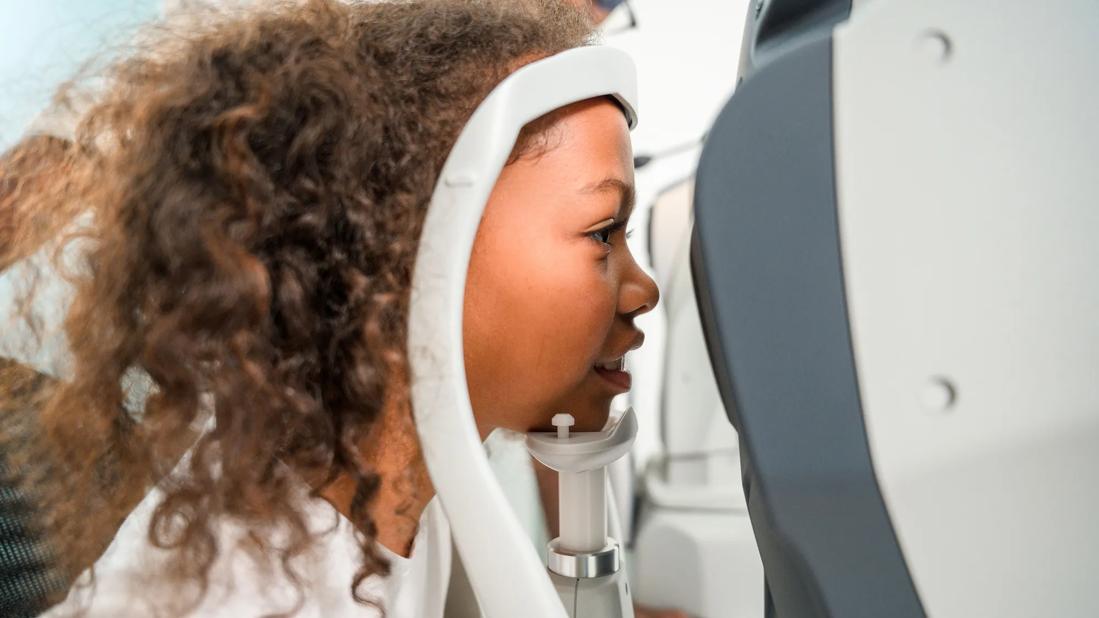 Child with head in chin rest getting an eye exam