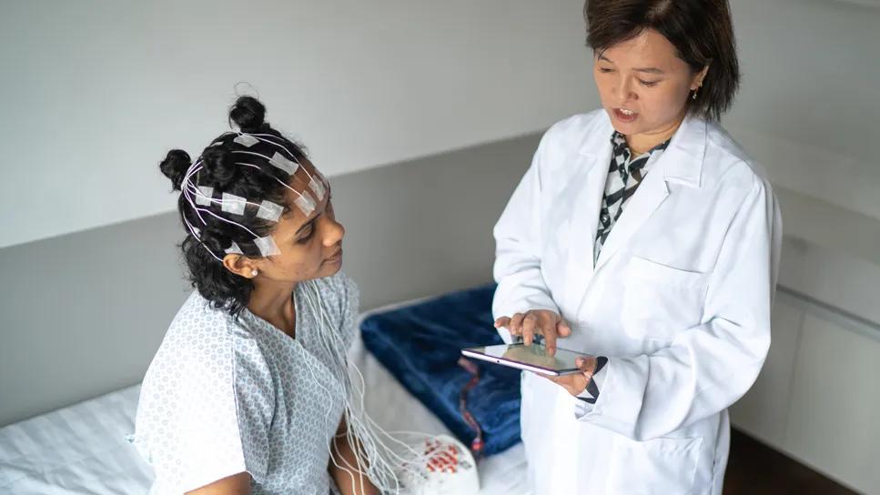 woman preparing for sleep study with healthcare provider