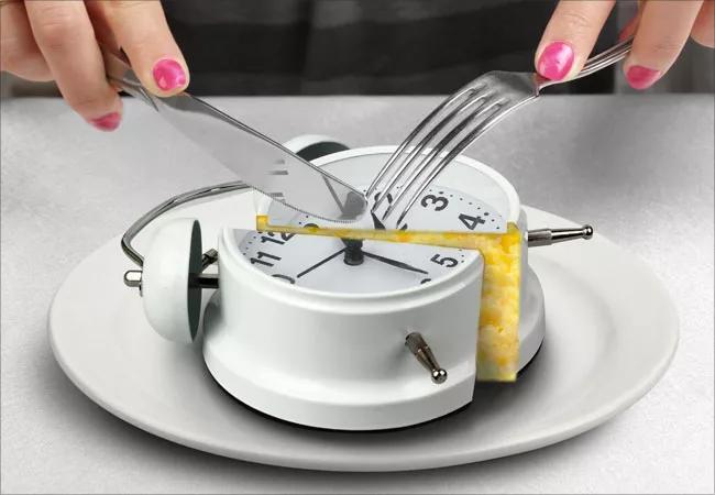 A knife and fork cutting a clock.