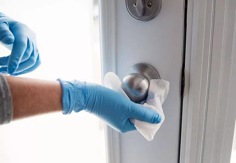 disinfecting wipes being used to clean doorknob