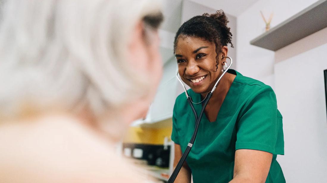 Caregiver smiling at elderly patient