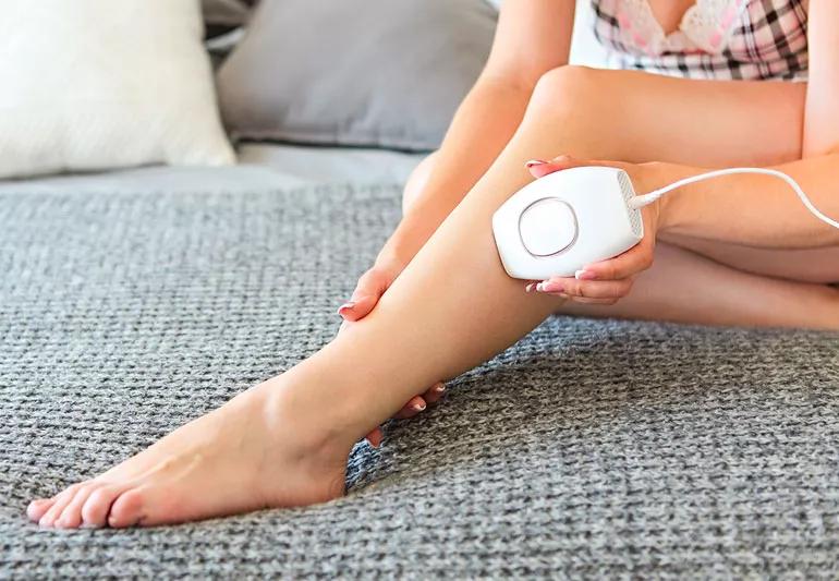 Woman using at-home laser hair removal on leg