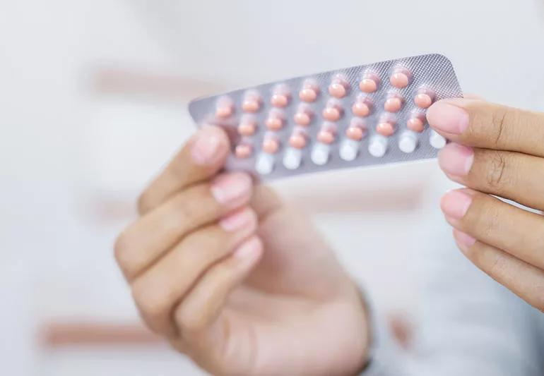 woman holding hormone therapy birth control pills
