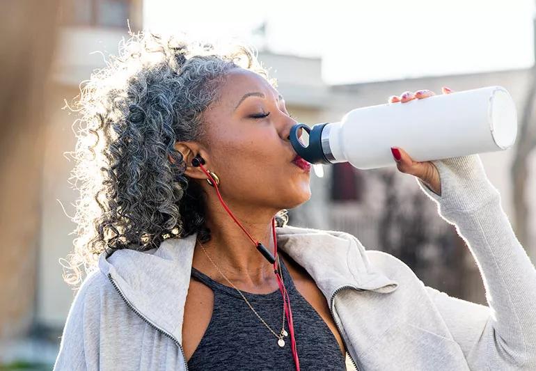 woman drinking water while exercising