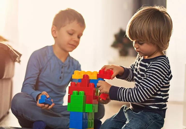 Two young boys playing with building blocks