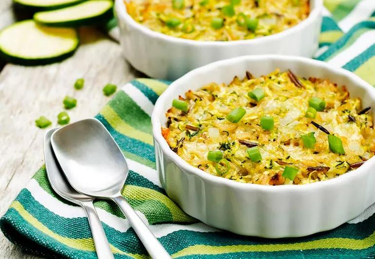 Turkey, Rice and Zucchini casserole in white bowl on a green striped cloth.