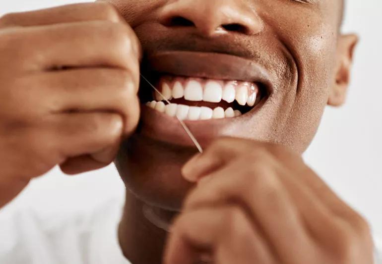 man flossing teeth