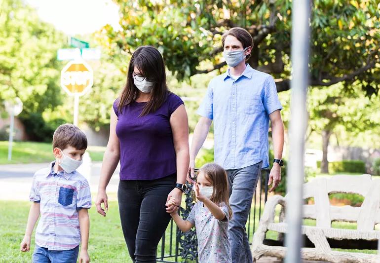 Family taking a walk while wearing masks