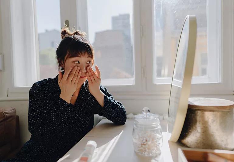 Person applying eye cream.