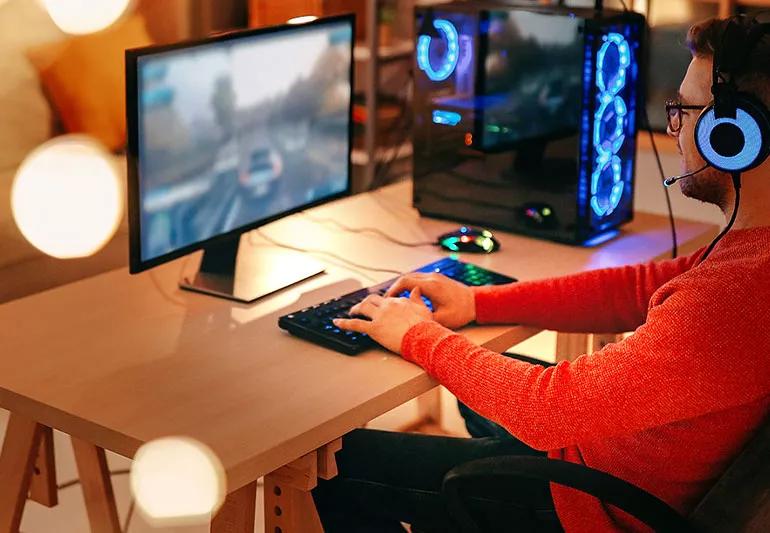 A man at a personal computer playing video games