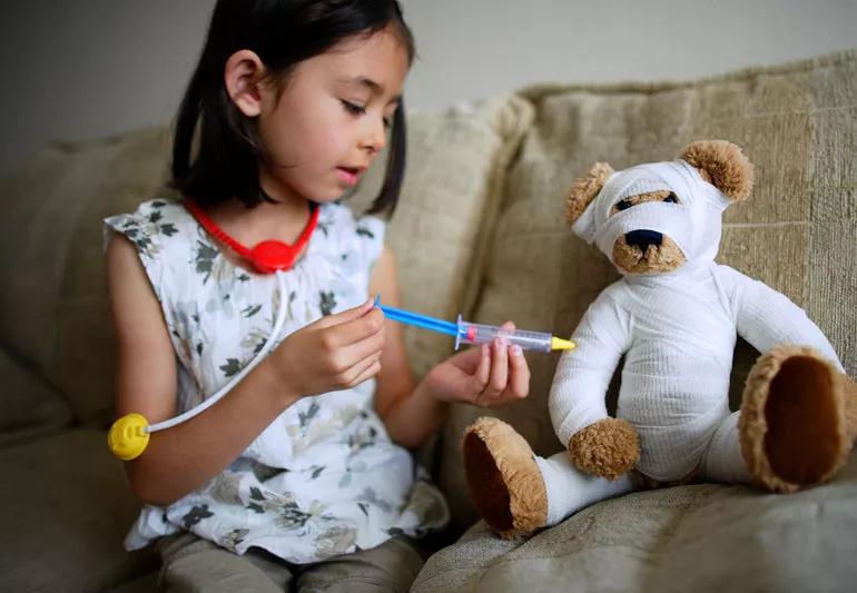 young girl playing with her stuffed animal