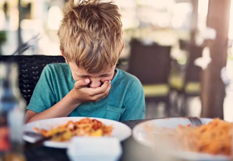 Little boy getting sick at restaurant due to allergic reaction