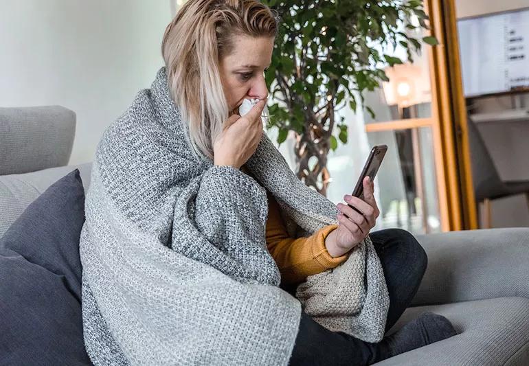 woman sick and using smartphone
