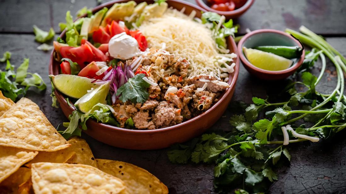 Taco salad with rice in a bowl and tortilla chips on the table