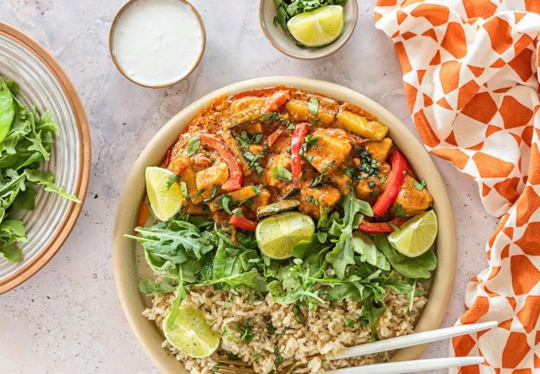 A bowl of rice topped with Thai swordfish in a red curry sauce