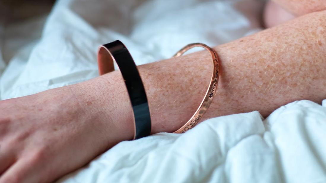 An arm with two copper bracelets on