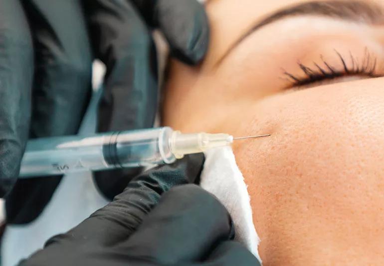 woman getting dermal filler in her cheek