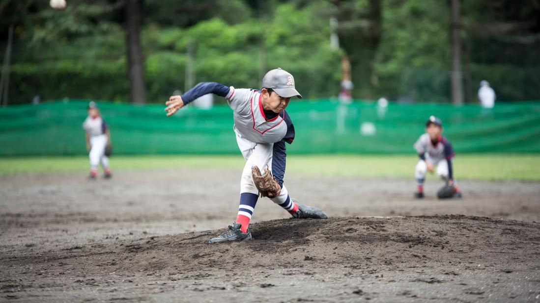 Young child in uniform pitches baseball during game