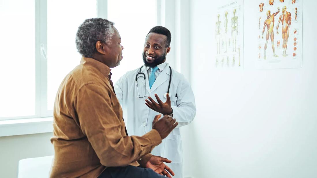 Healthcare provider consulting with male patient in exam room