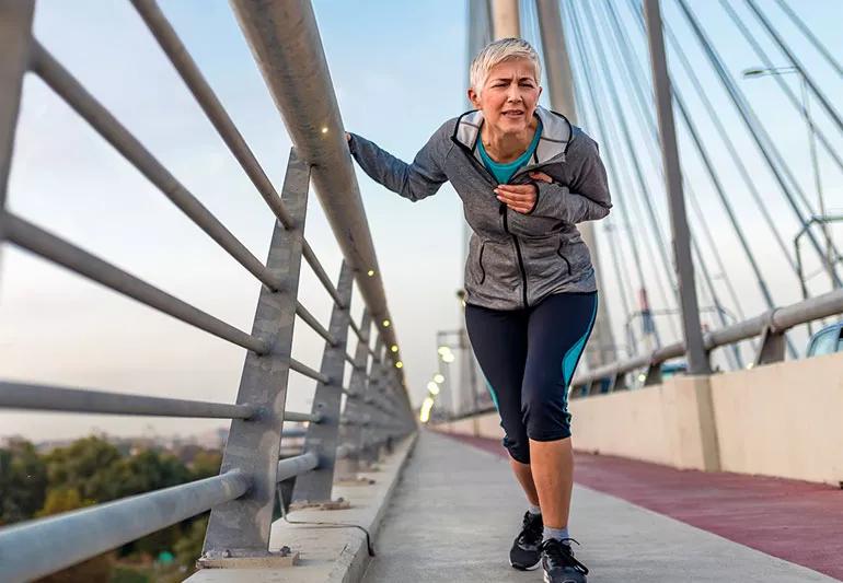 woman having chest pain while running