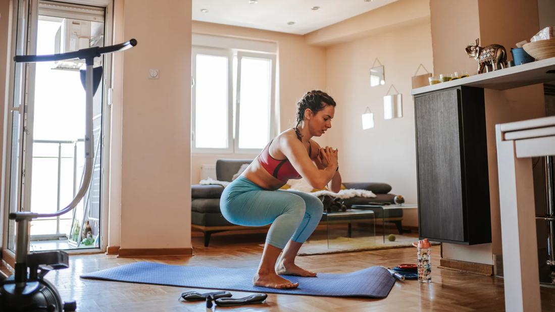 Person doing squats on mat at home