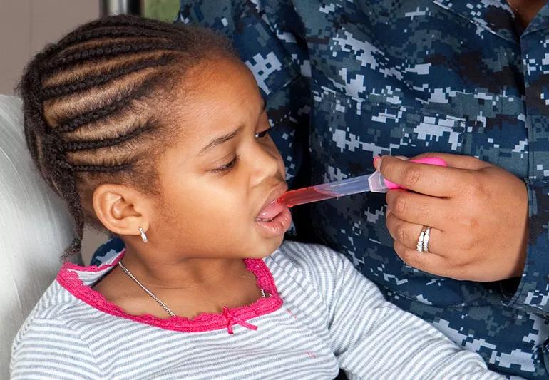 Mom giving medication to child