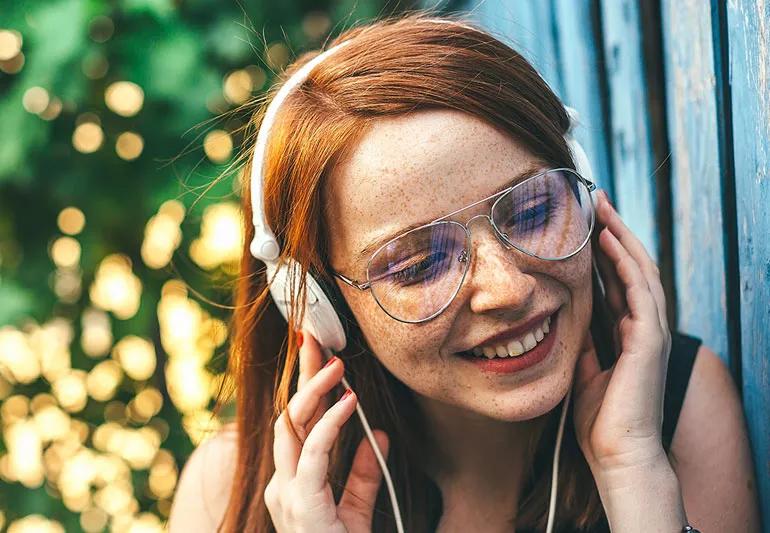 Young woman with freckles listening to music