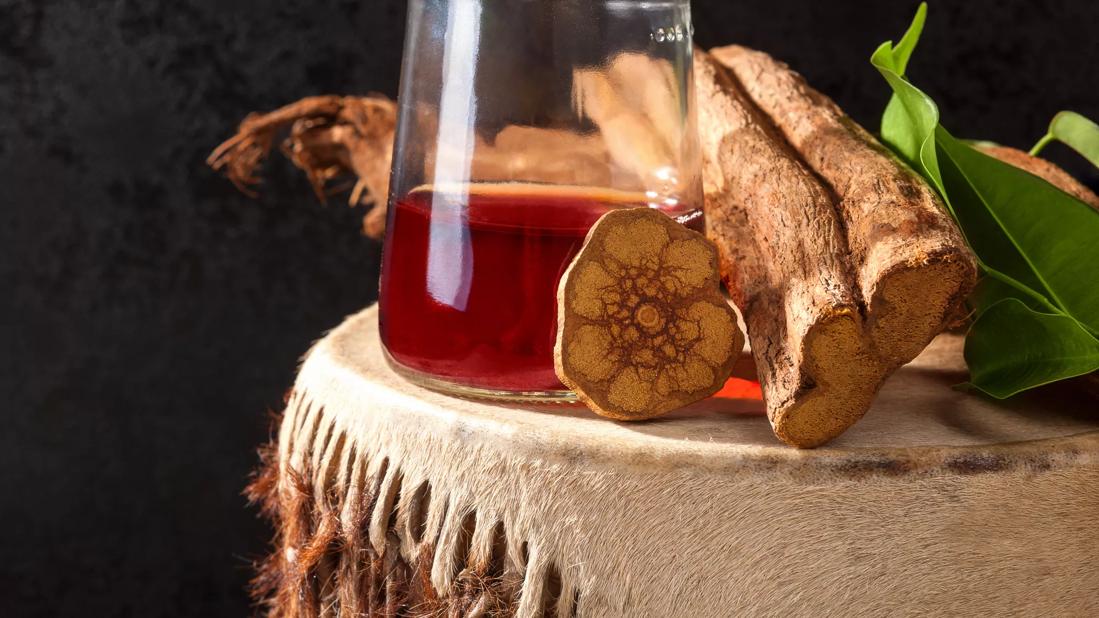 Glass of ayahuasca tea on stump