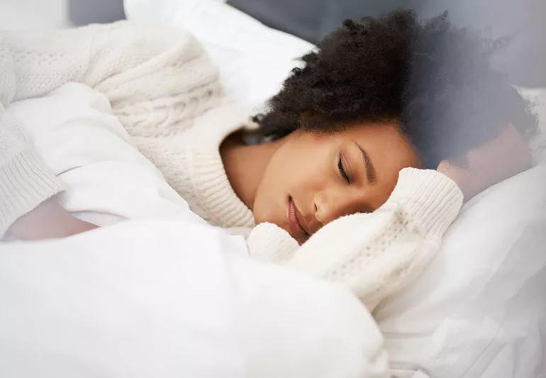 Woman sleeping in bed taking a nap.