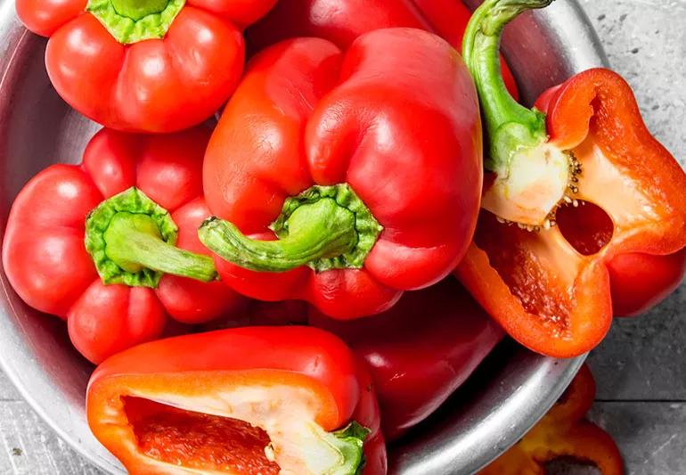 Closeup of vitamin C rich red peppers in a silver bowl.