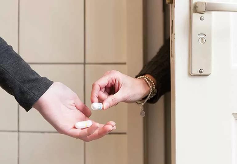 Woman getting handed a tampon.