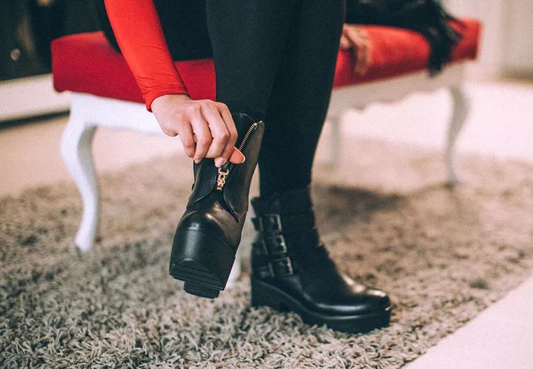 woman trying on boots at store