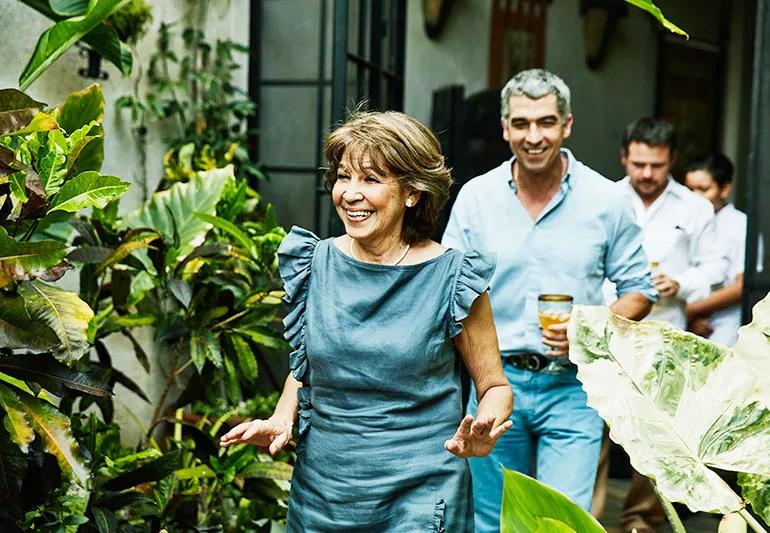 Smiling, unmasked guests walking into an outdoor party area.