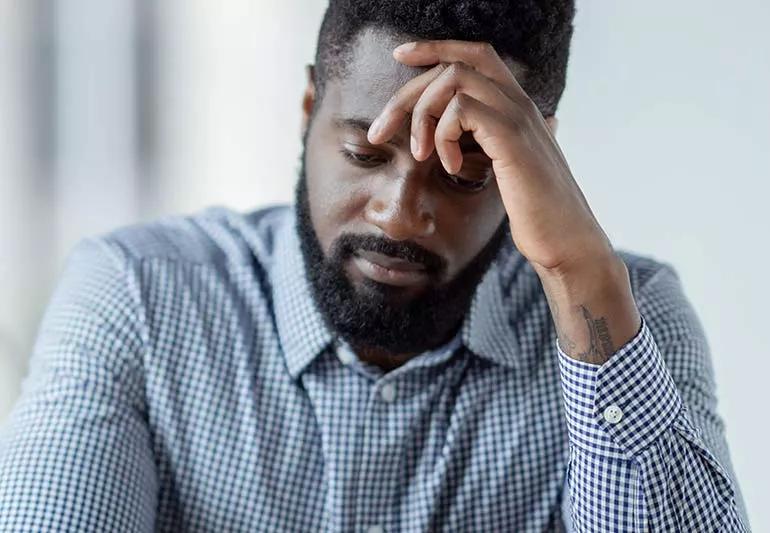 Man holding head looking worried or depressed.