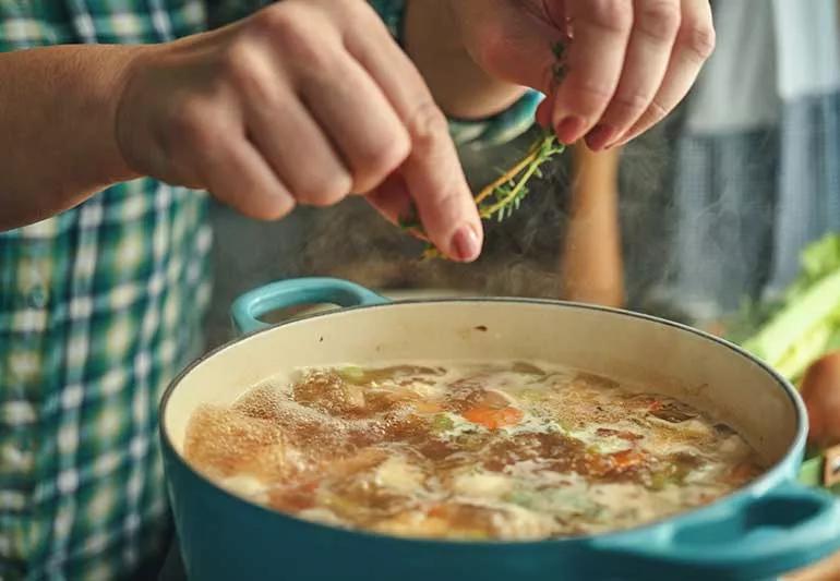 Someone cooking chicken noodle soup.