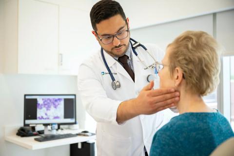 Doctor examines patient's neck