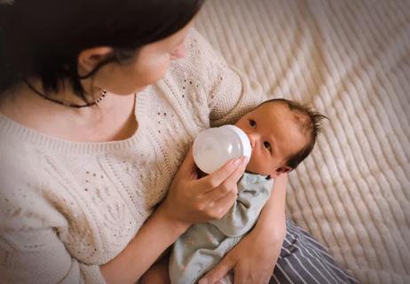 Parent feeds baby before bed.