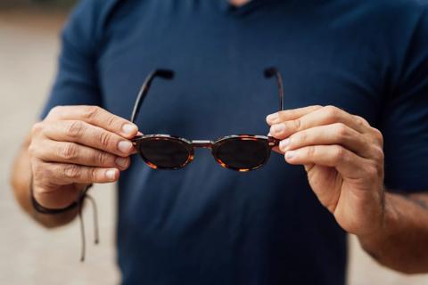 Person holding up sunglasses