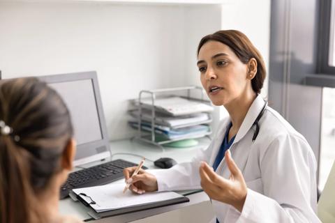 Healthcare provider talking to a female patient in office