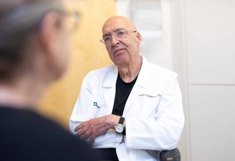 Dr. Calabrese listening to a patient in an office setting