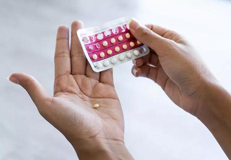 A close up of someone holding birth control pills