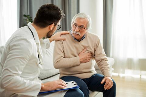 Healthcare provider with hand on older patient's shoulder, discussing heart