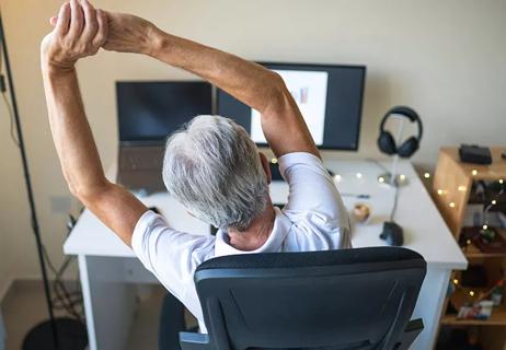 Individual sitting at work desk stretches