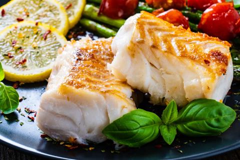 A plate of baked cod and vegetables