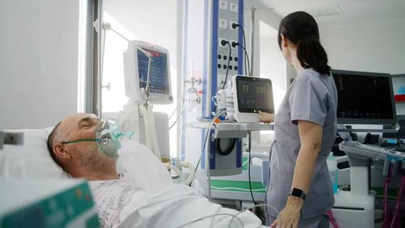 man in hospital bed wearing ventilation mask