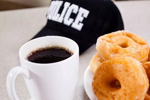 Cup of coffee, donut and police cap