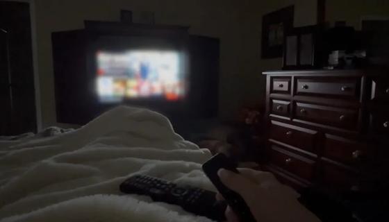 Person watching TV in bed